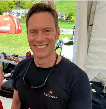 A man smiles at the camera and gives the thumbs up